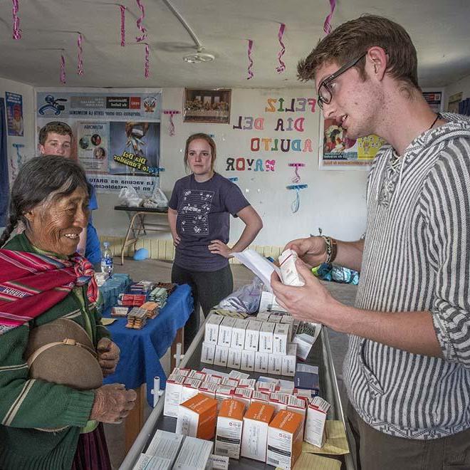 Male student discussing prescriptions with Peruvian woman